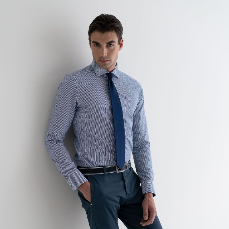 Ragazzo con camicia fil coupè azzurra e blu con cravatta